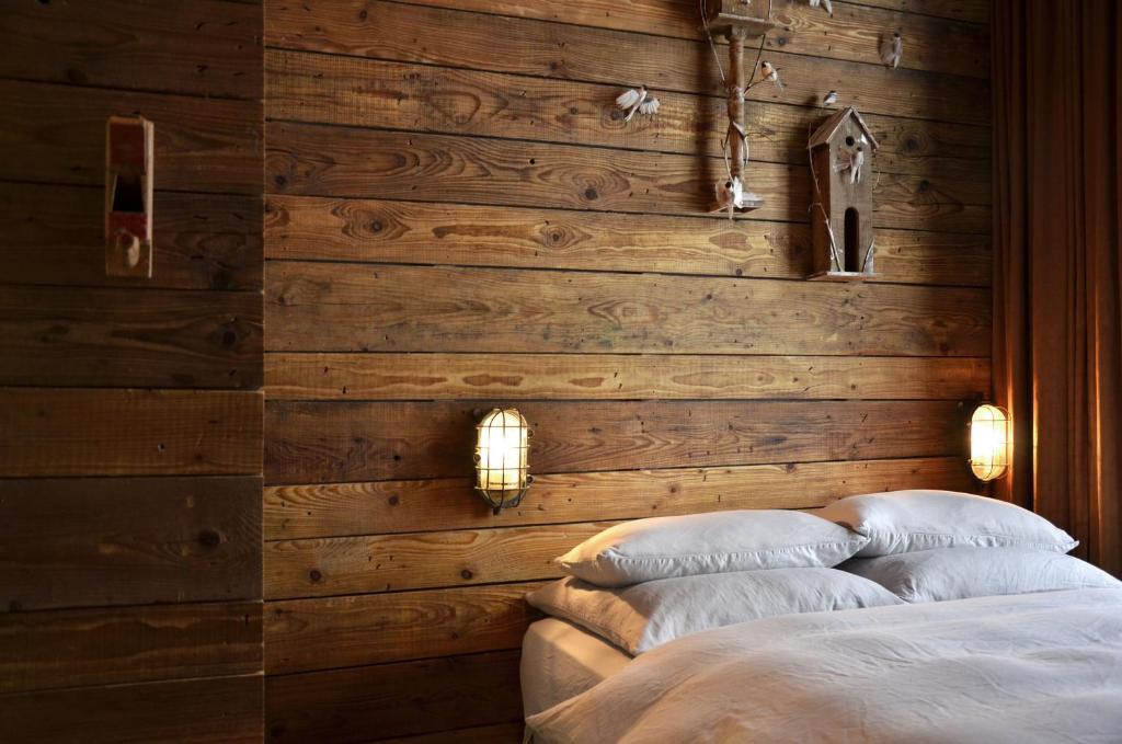 柏林林恩酒店的一间卧室设有木墙,床上配有两个枕头