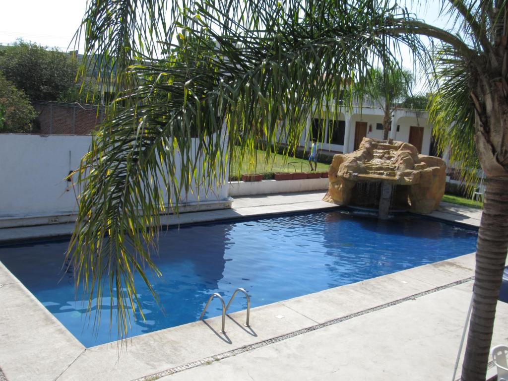 库奥特拉莫雷洛斯Hotel Real de Cuautla的棕榈树和喷泉的游泳池