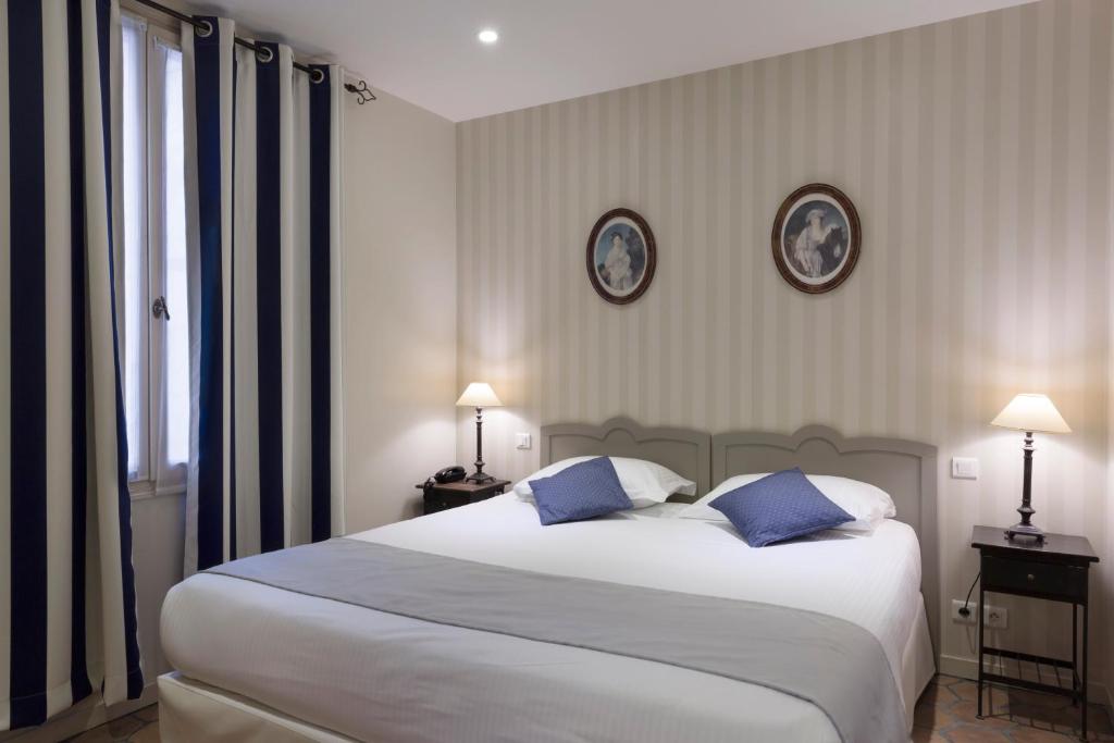 巴黎莫加多尔酒店的卧室配有带蓝色枕头的大型白色床