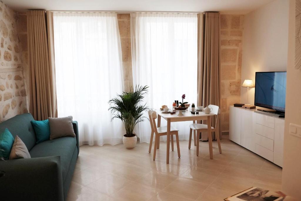 巴黎圣安娜花园公寓的客厅配有桌子和蓝色沙发
