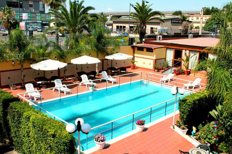 米斯泰尔比安科Hotel La Villa的享有带椅子和遮阳伞的游泳池的上方景色