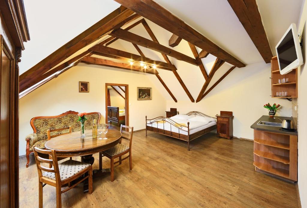 捷克克鲁姆洛夫普雷拉塔酒店的客厅配有桌子和床。