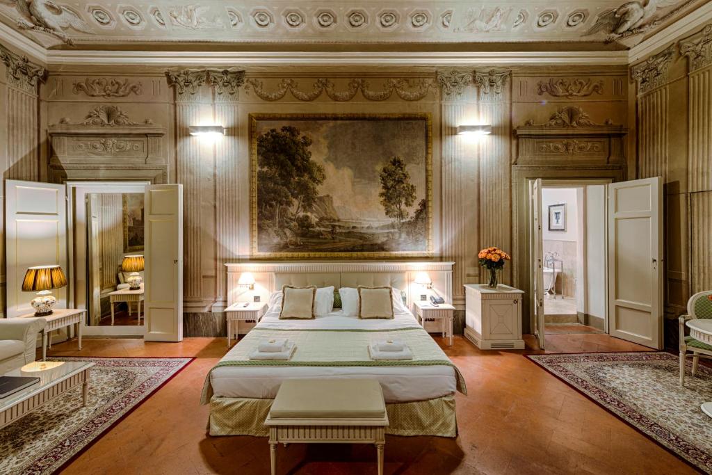 佛罗伦萨奎恰尔迪尼宫殿酒店的卧室配有一张床,墙上挂有绘画作品
