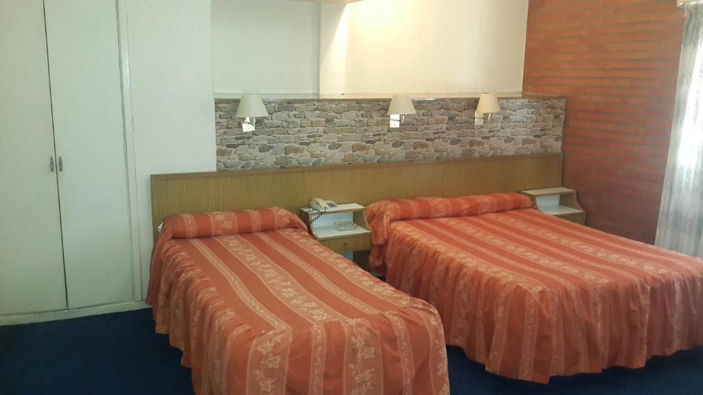 布宜诺斯艾利斯外交官酒店 的配有橙色床单的酒店客房内的两张床