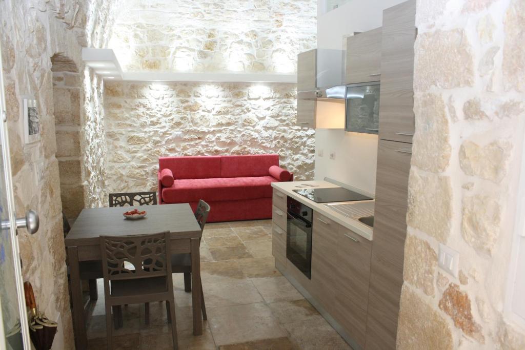 莫尔费塔Lilla B&B Luxury Apartments的厨房配有红色的沙发和桌子