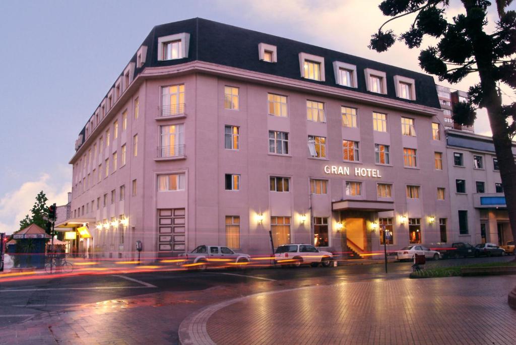 奇廉伊莎贝尔里克尔梅格兰酒店的一座大型建筑,前面有汽车停放