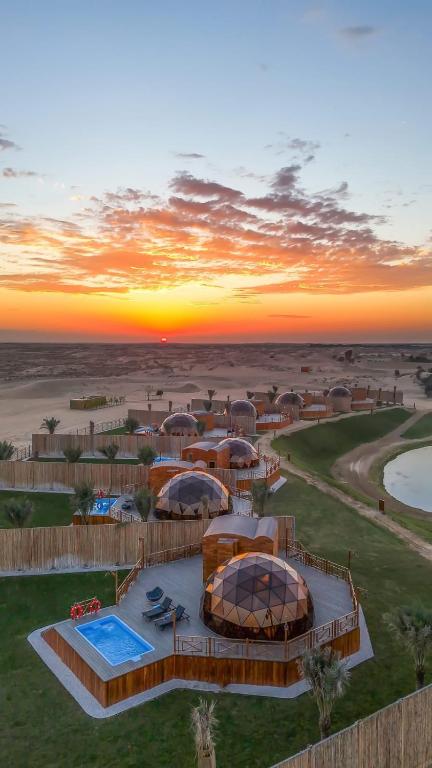迪拜Al Marmoom Oasis Luxury Experiential Desert Domes的享有度假胜地的空中美景和日落美景