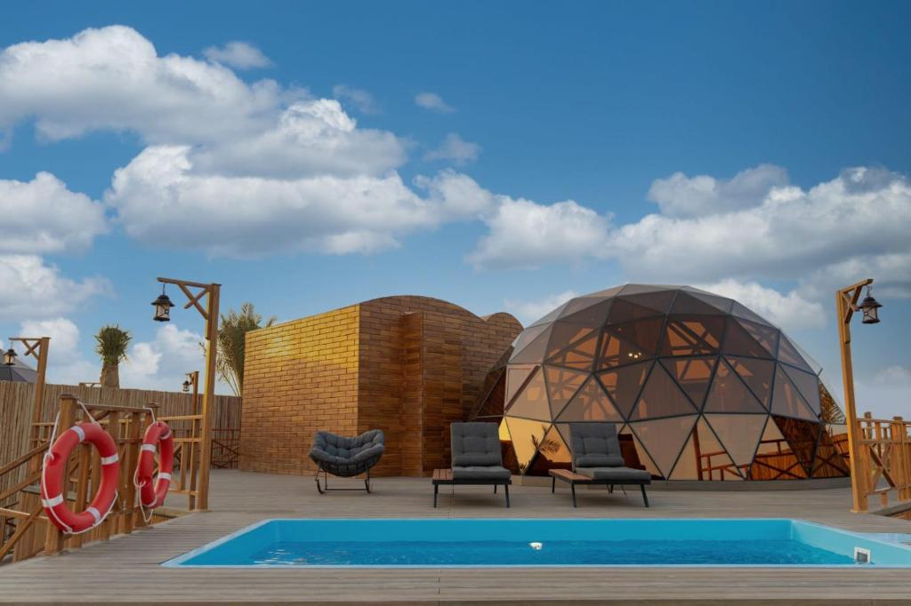 迪拜Al Marmoom Oasis Luxury Experiential Desert Domes的一个带圆顶和游泳池的度假村