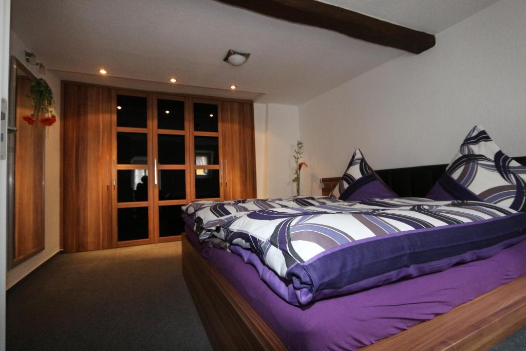 摩泽尔河畔的泽尔Ferienhaus DaVinci的一间卧室配有一张带紫色和白色棉被的床