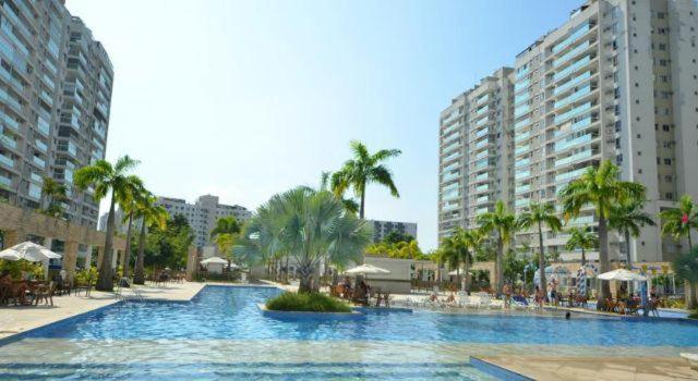 里约热内卢卢克索巴拉公寓式酒店的一座棕榈树和建筑的大型游泳池