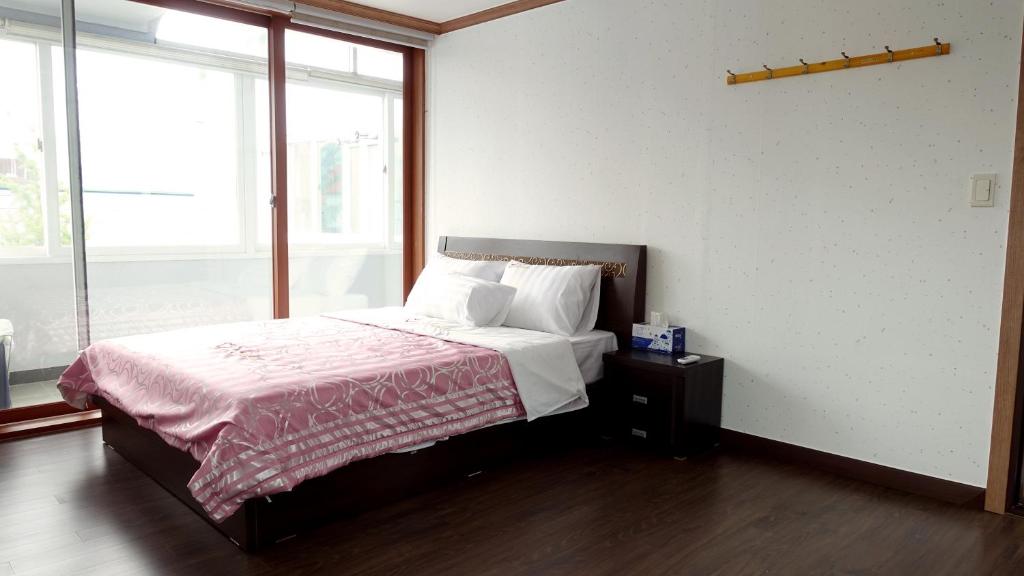 全州市美好回忆旅馆的一间卧室设有一张床和一个大窗户