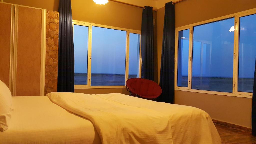 Al QārinMasirah Beach camp的一间卧室配有一张床,享有海景