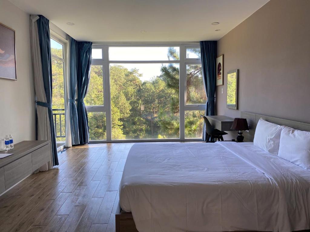 大叻Lan Anh Villas Resort的一间带大床和大窗户的卧室
