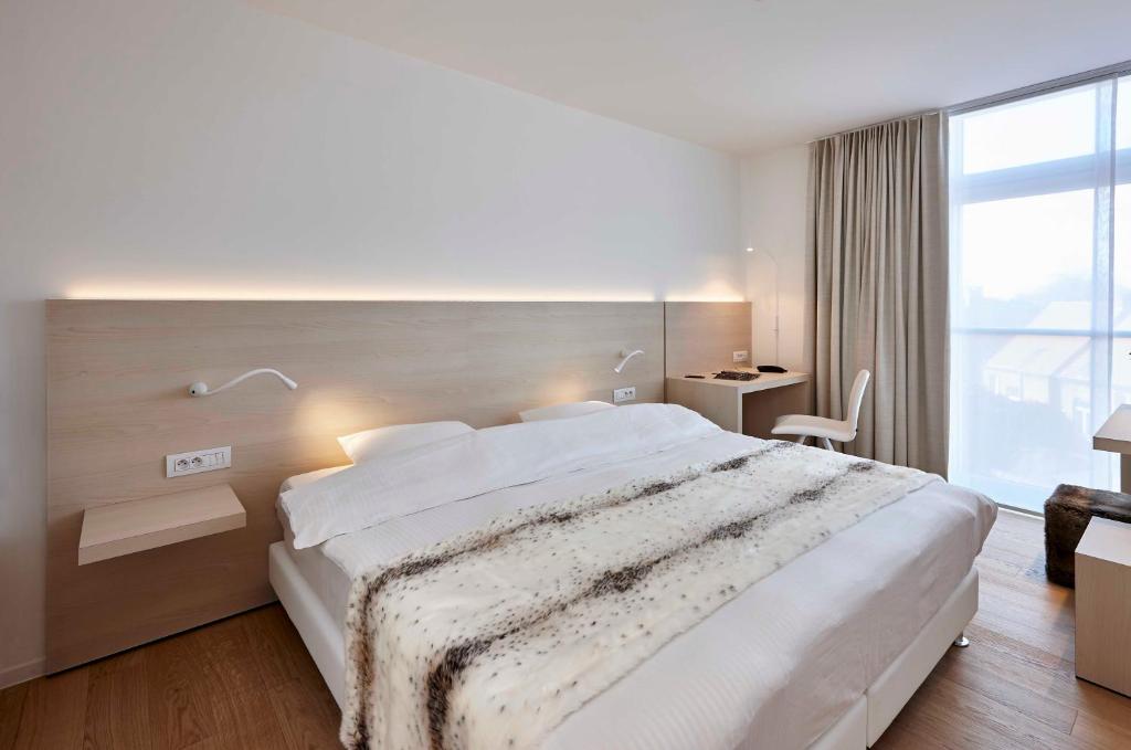 伊泽海姆伊泽赫姆公园酒店的一间卧室设有一张大床和一个大窗户