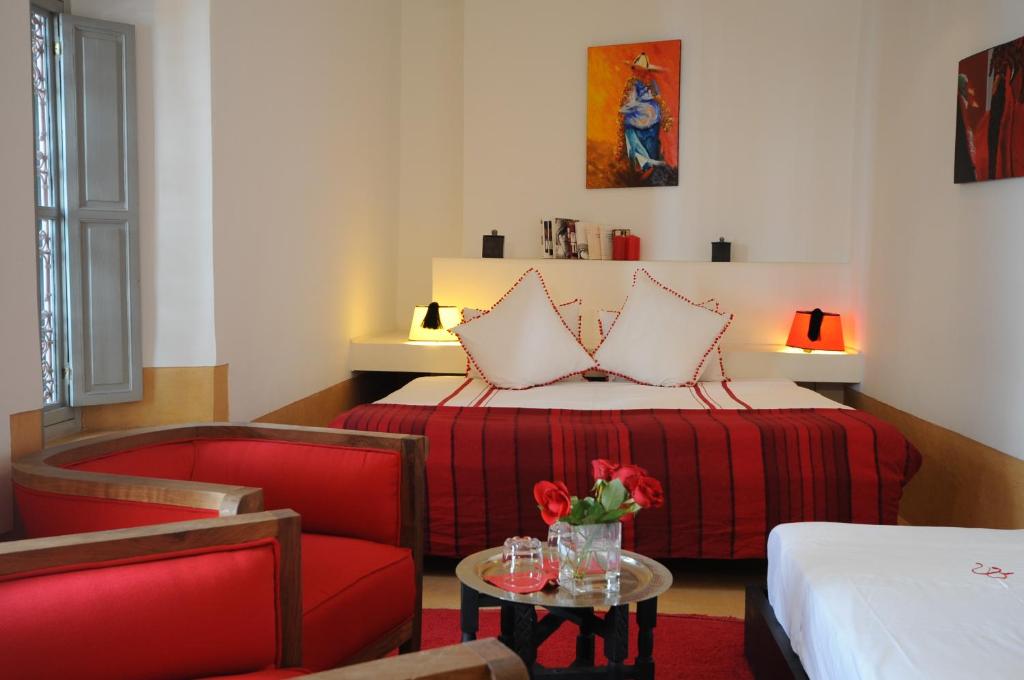 马拉喀什里亚德达阿森旅馆的配有床、椅子和桌子的酒店客房