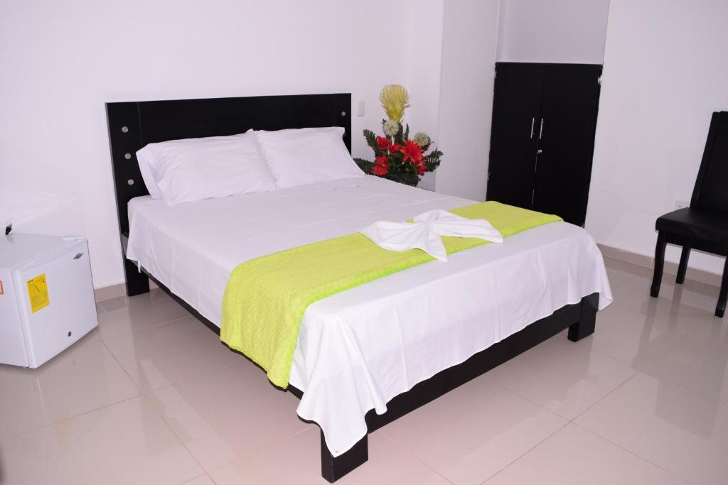 里奥阿查Karin Hotel的一间卧室配有一张带黄色毯子的大床