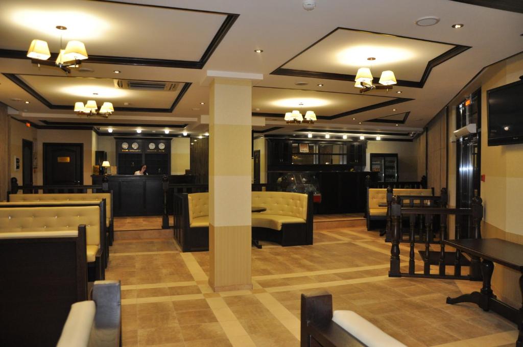 叶森图基Bugar Hotel的用餐室配有桌椅和灯光