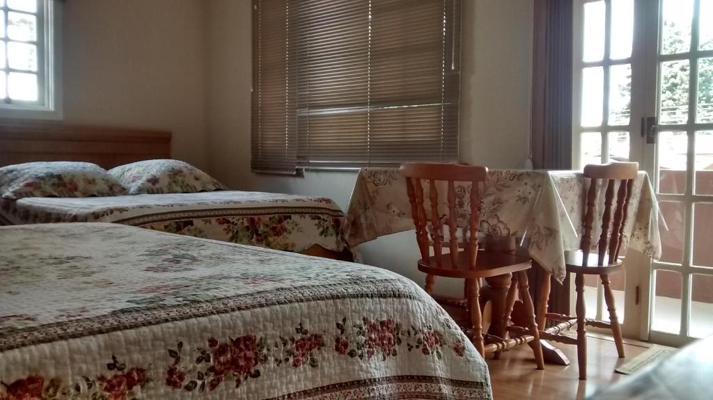 格拉玛多艾斯特瑞拉托旅馆的一间卧室设有两张床和两把椅子,窗户