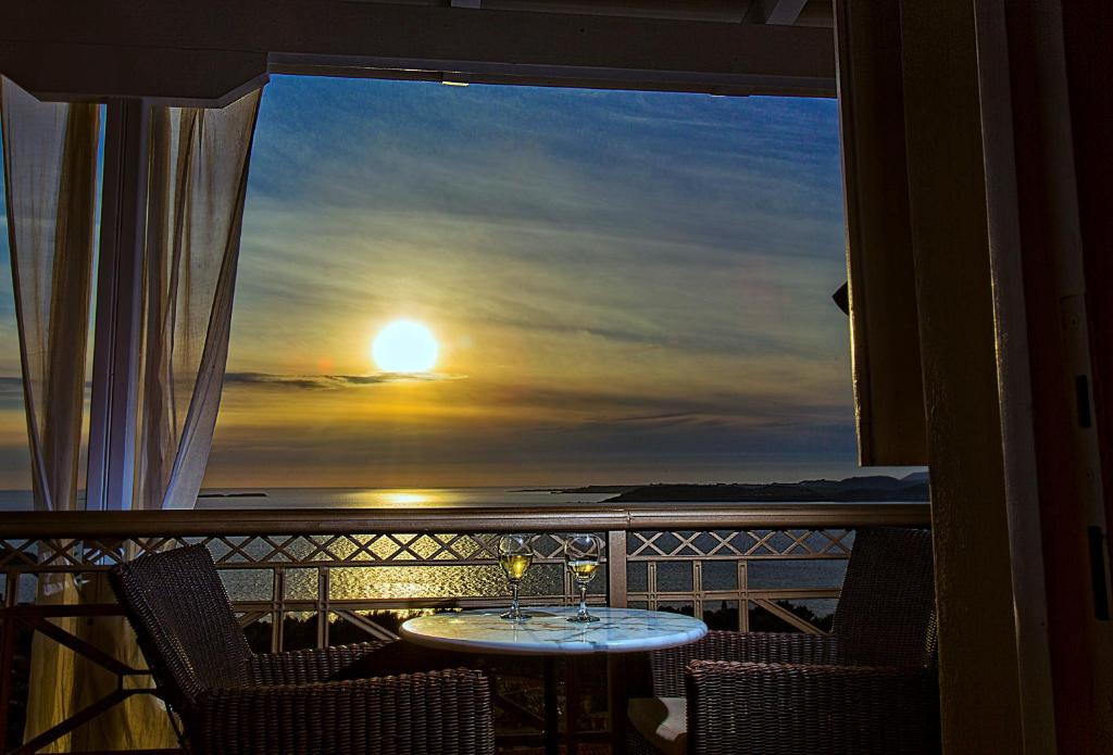 拉瑟阳光度假村的阳台享有日落美景,配有桌椅。