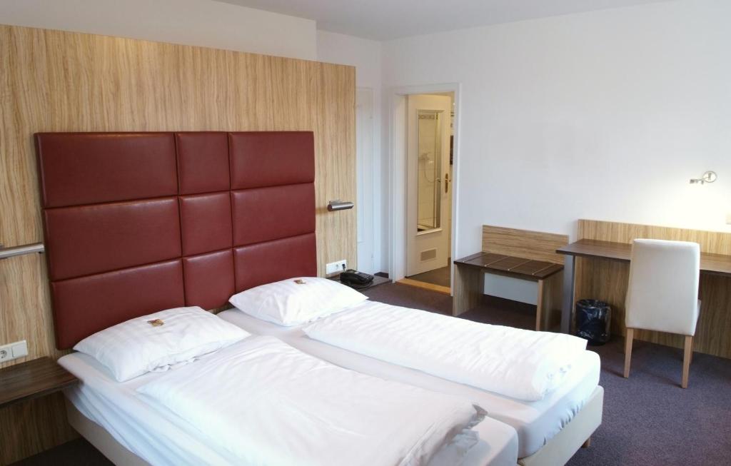 海德堡盖斯豪斯拜科穆德酒店的酒店客房配有两张床和一张书桌