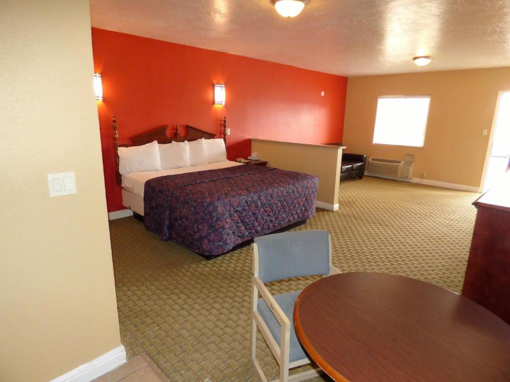 圣乔治经济套房酒店的酒店客房配有一张床铺和一张桌子。