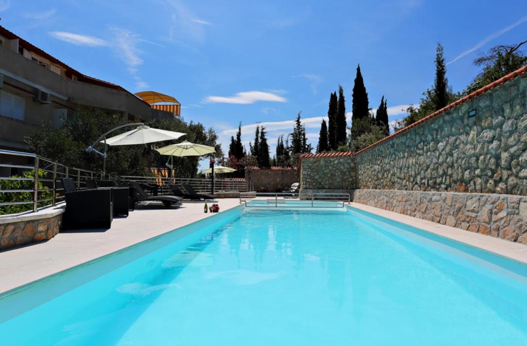 卡利Villa Dinastija的一座大型蓝色游泳池,毗邻石墙