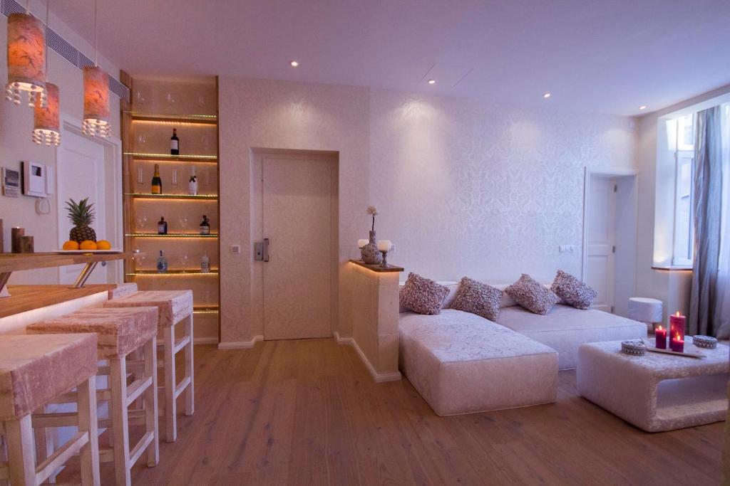 马略卡岛帕尔马帕尔马设计套房酒店 的带沙发的客厅和带凳子的酒吧