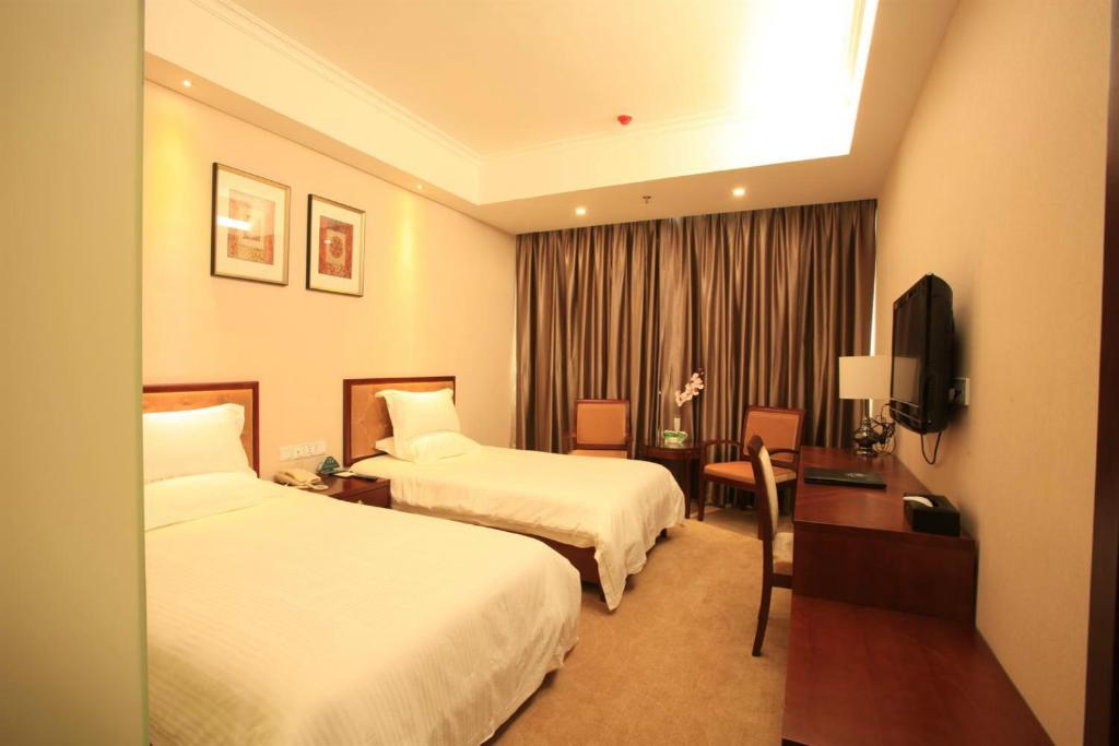 天津格林豪泰天津市大悲院商务酒店的酒店客房配有两张床和一张书桌