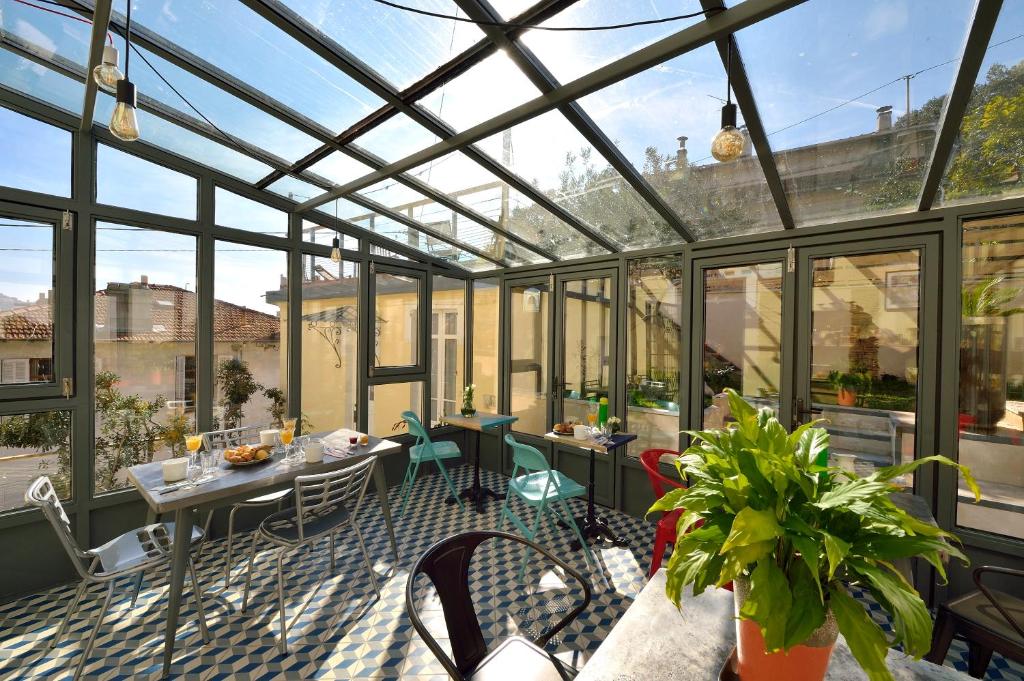 戛纳杜拉克弗罗瑞别墅住宿加早餐旅馆的玻璃温室,配有桌椅