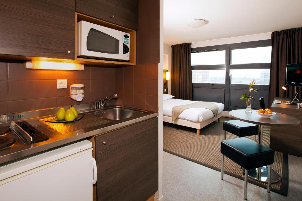 里尔欧洲里尔住宿及商务酒店的酒店客房设有厨房和卧室
