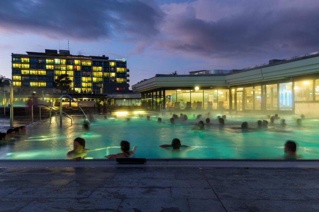 巴德楚尔察赫VitalBoutique Hotel Zurzacherhof的一群人晚上在游泳池里
