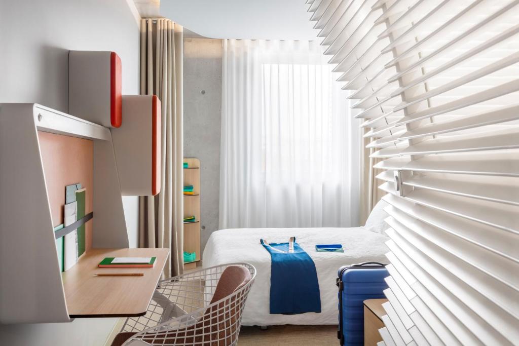 戛纳戛纳中心奥克酒店的卧室配有一张床和一张桌子及椅子