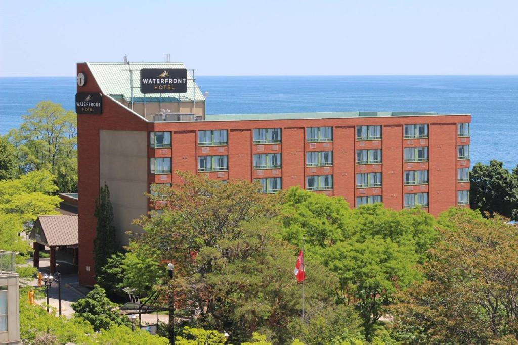 伯灵顿Waterfront Hotel Downtown Burlington的一座红砖建筑,背景是大海