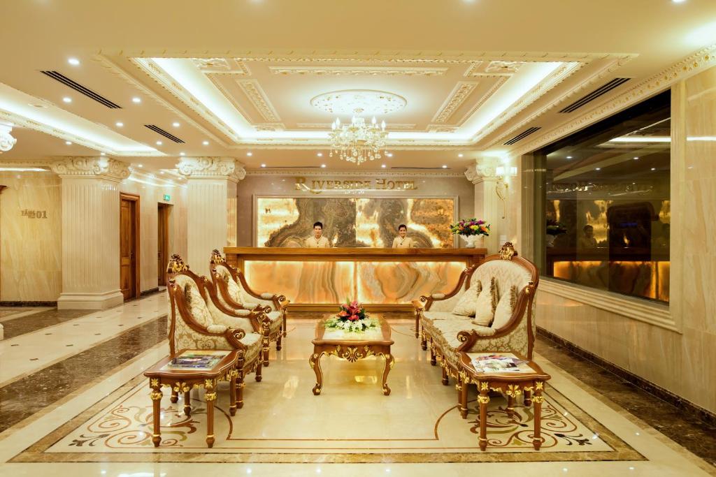 洞海Riverside Hotel Quang Binh的大堂设有椅子、桌子和吊灯。