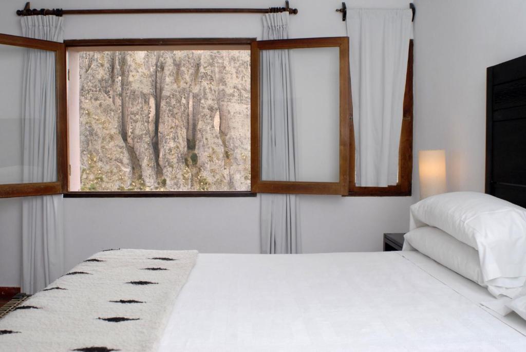 伊鲁亚Hotel Iruya的卧室配有白色的床和窗户。