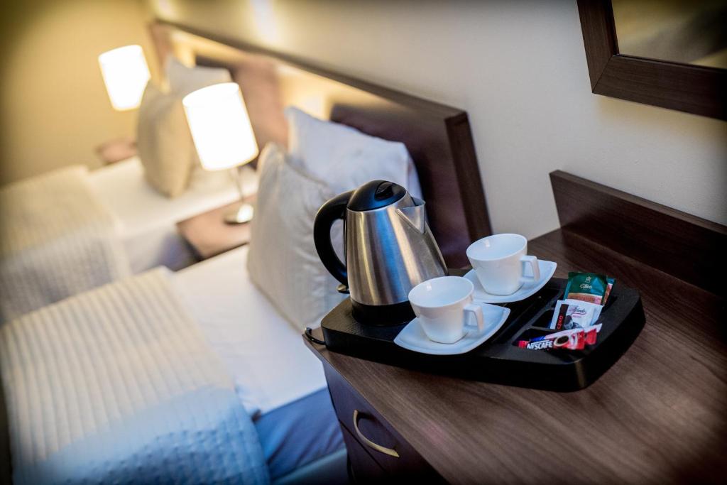 塔尔努夫坎托利亚酒店的床上的茶壶和杯子托盘