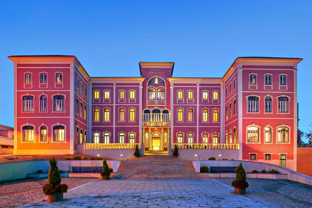 蒙特里尔Monte Real - Hotel, Termas & Spa的一座大型粉红色建筑,前面设有楼梯