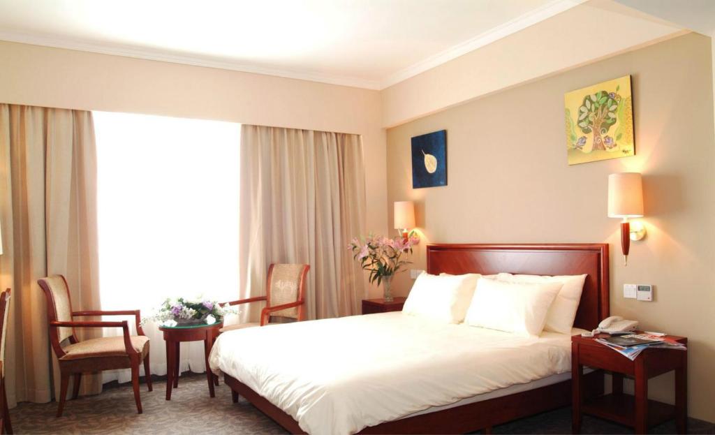张家口格林豪泰张家口公安大厦快捷酒店的酒店客房带床、椅子和窗户