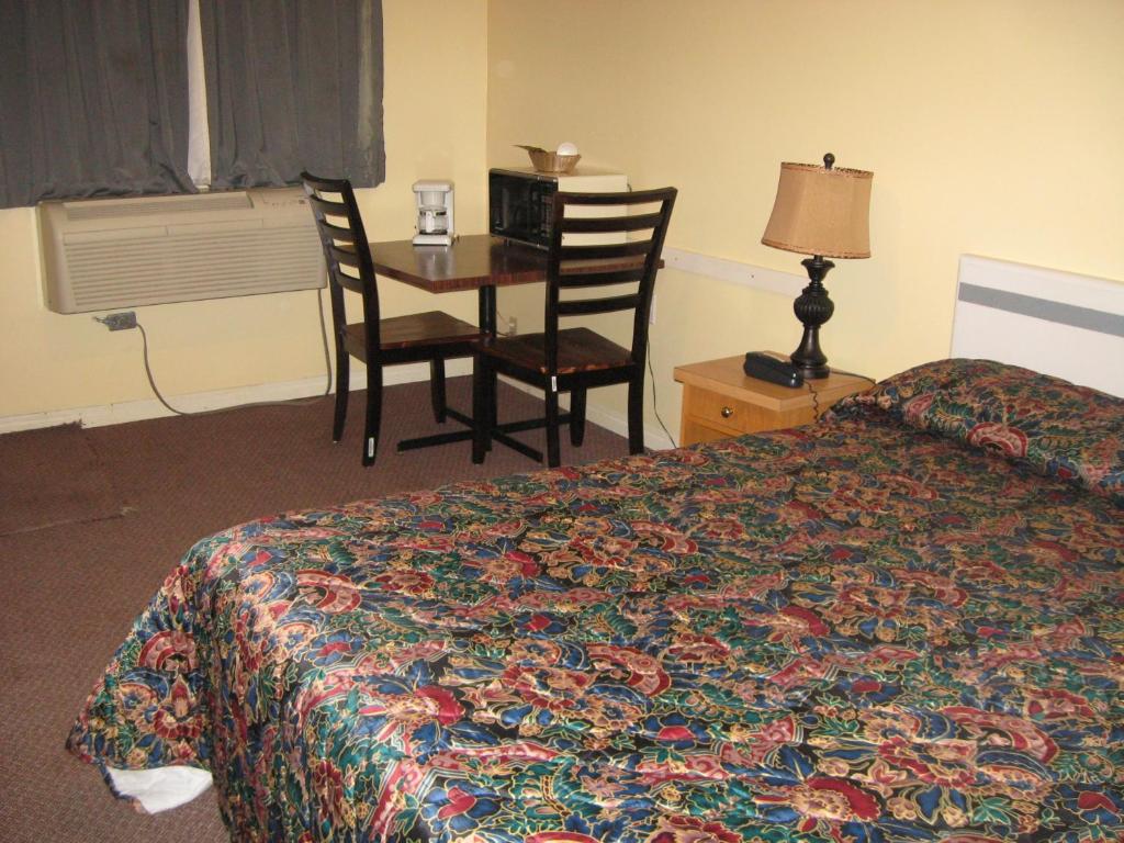 梅迪辛哈特帕尔斯汽车旅馆和RV公园的酒店客房带一张床、一张桌子和椅子