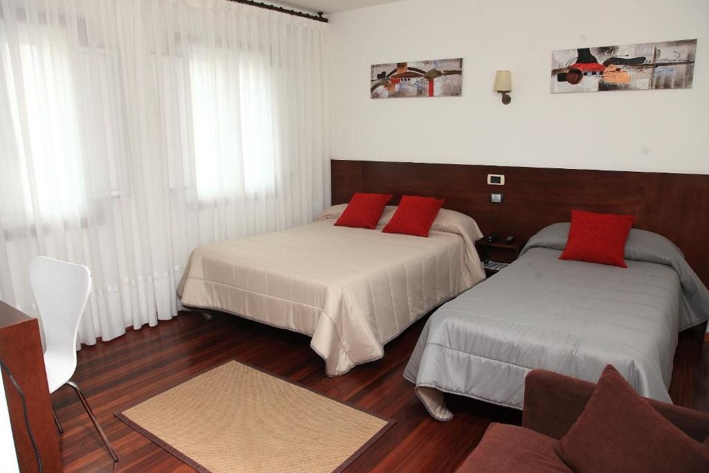 庞特维德拉鲁阿斯酒店及餐厅的客房 - 带两张带红色枕头的床