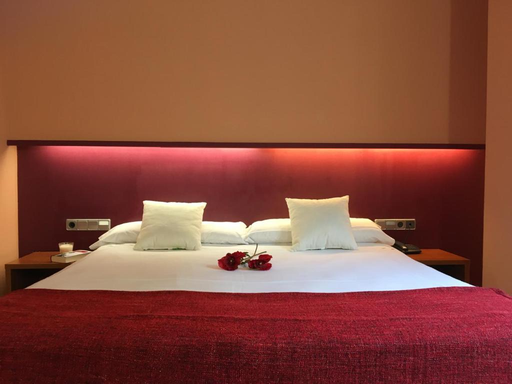 拉洪克拉拉洪奎拉酒店的一间卧室配有一张大床和红色床头板