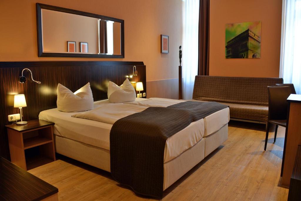 慕尼黑慕尼黑艺术酒店的酒店客房设有一张大床和一张沙发。