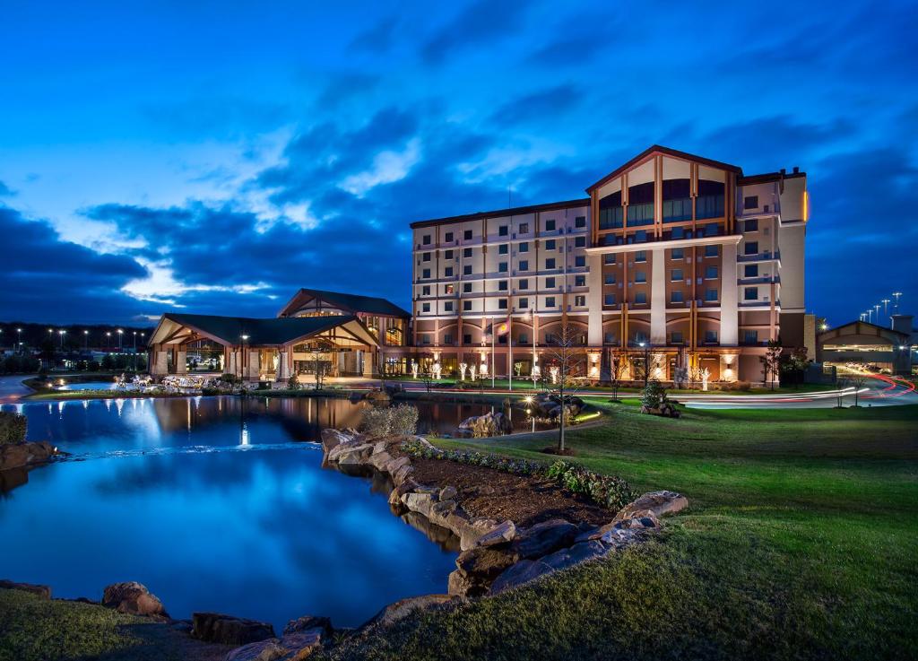 PocolaChoctaw Casino Hotel – Pocola的一座大建筑,前面有一个池塘