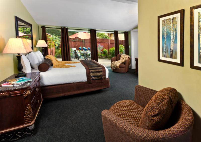 太平洋丛林蒙特雷半岛酒店 的卧室配有一张床、一张桌子和椅子