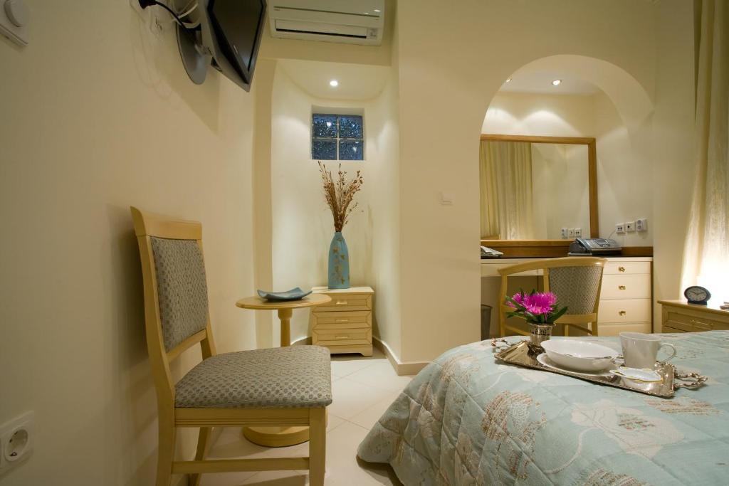 安德罗斯Andria Suites的卧室配有一张床和一张桌子及椅子