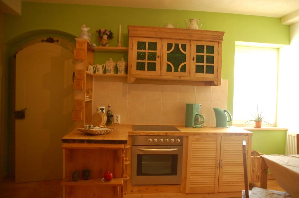 CunnersdorfFerienwohnung Katzstein的厨房配有木制橱柜和炉灶烤箱。