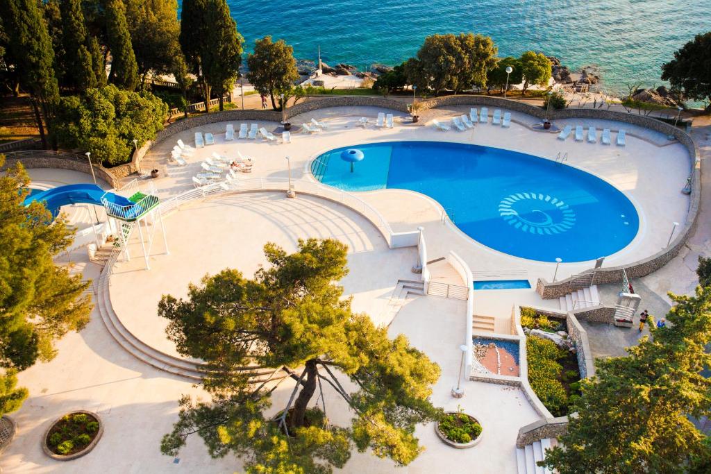 克尔克Hotel Dražica - Hotel Resort Dražica的享有大海旁大型游泳池的顶部景致