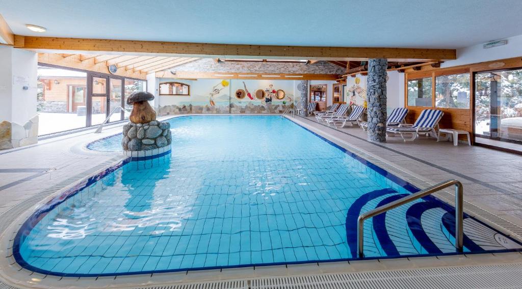 拉夏贝尔德邦达Hôtel L'Ensoleillé的游泳池,位于酒店带游泳池的房间内