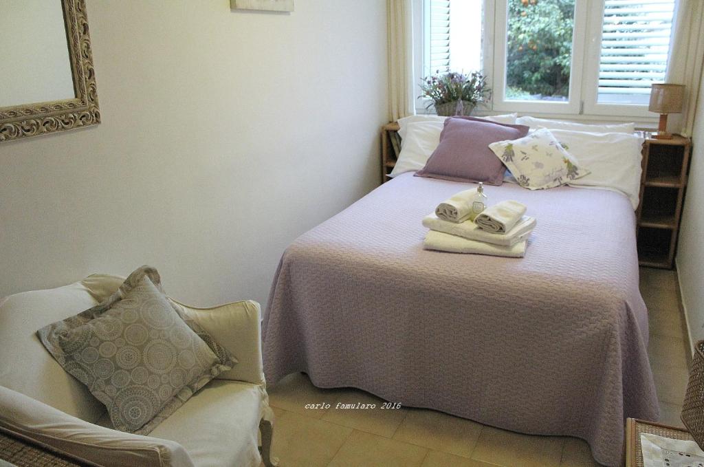 卡普里阿波罗别墅住宿加早餐旅馆的一间卧室配有带毛巾和椅子的床
