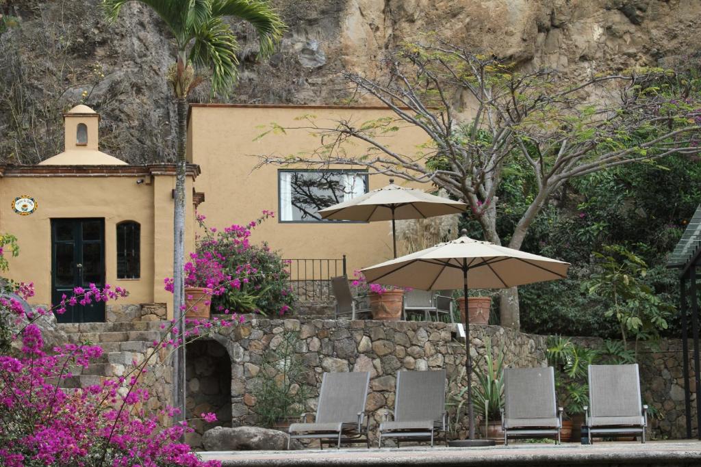 马利纳尔科Casa Alamillo Hotel Boutique的一组椅子和遮阳伞在房子前面